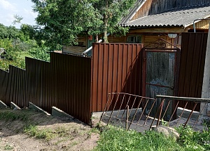 Забор из металлопрофиля (темно-коричневый) на косогоре